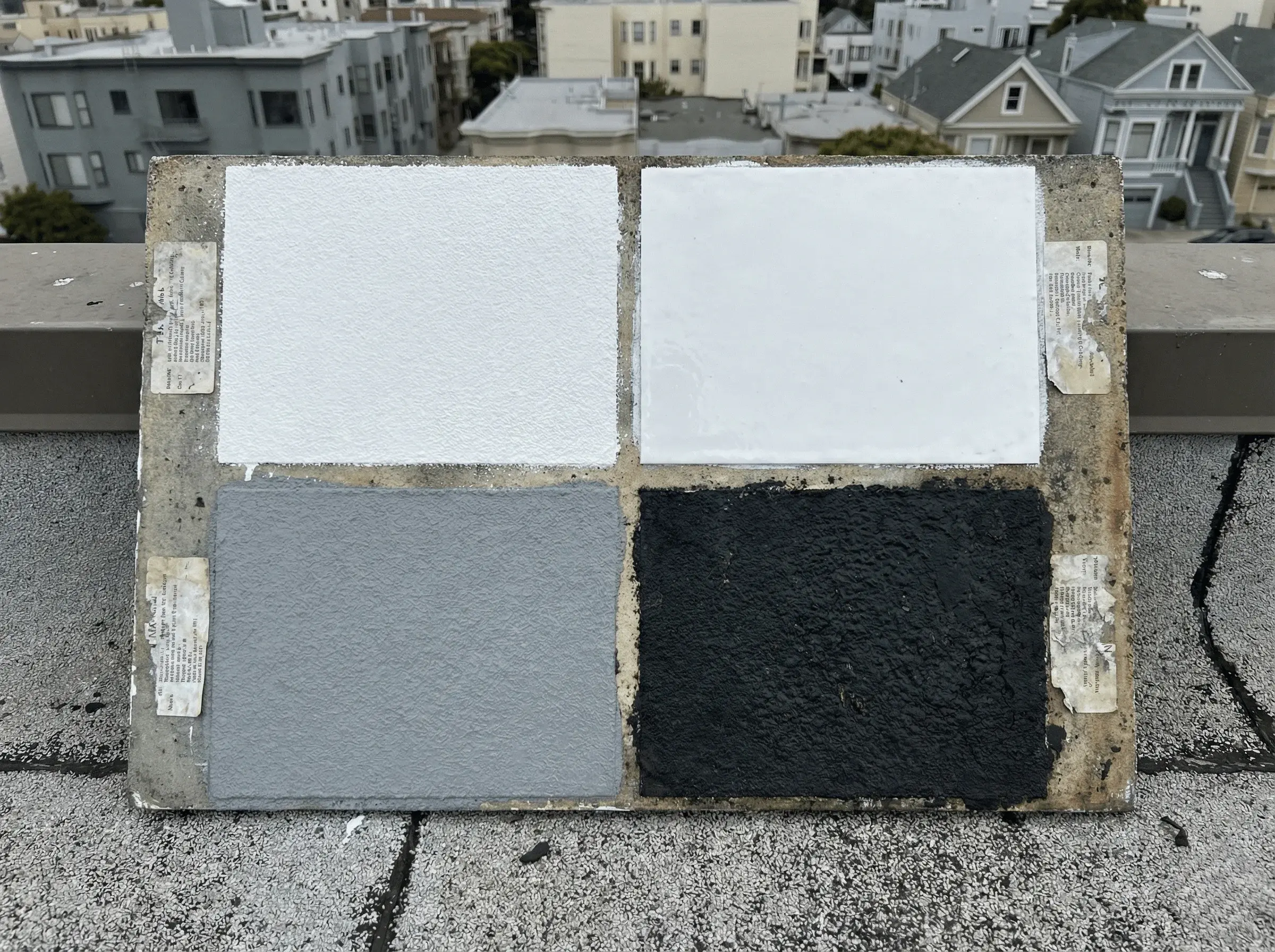 Comparison of multiple roof coating types on a test panel, showing different finishes and textures used on Bay Area roofs.